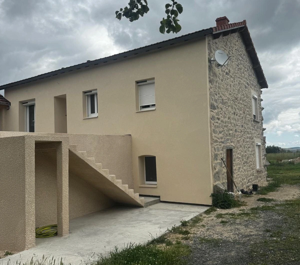 Ravalement enduit crépi beige – vue de profil avec mur en pierre restant apparent, Haute-Loire